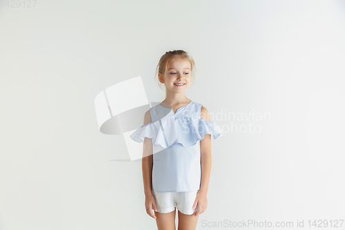 Image of Little smiling girl posing in casual clothes on white studio background