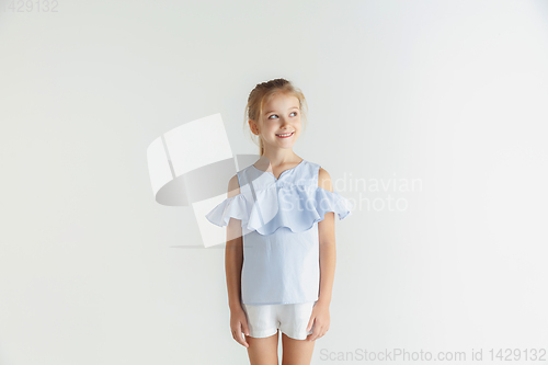 Image of Little smiling girl posing in casual clothes on white studio background