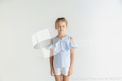 Image of Little smiling girl posing in casual clothes on white studio background