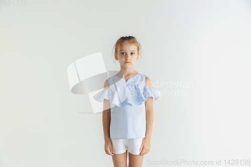 Image of Little smiling girl posing in casual clothes on white studio background