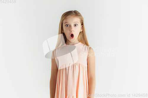 Image of Little smiling girl posing in dress on white studio background