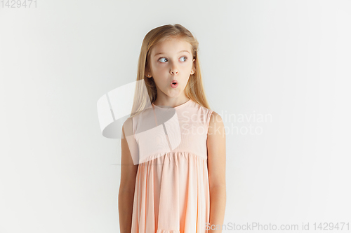 Image of Little smiling girl posing in dress on white studio background