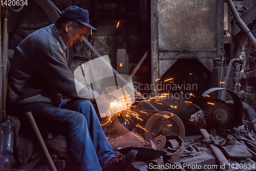 Image of the blacksmith polishing metal products