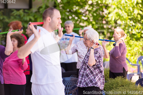 Image of trainer training motivated active healthy senior people