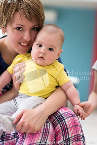 Image of Portrait of young happy mother holding newborn baby boy
