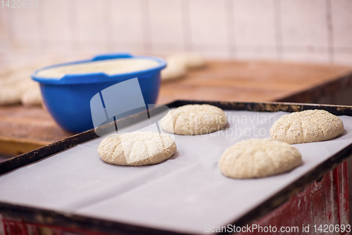 Image of balls of dough bread getting ready to be baked