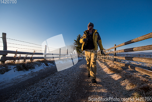 Image of young photographer walking on country road