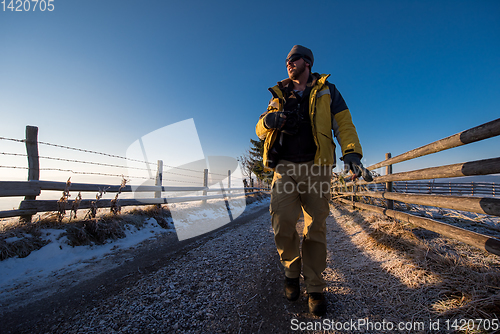 Image of young photographer walking on country road