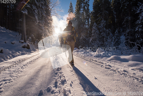 Image of young photographer walking on snowy country road