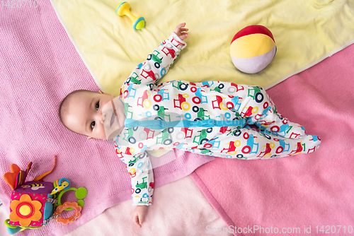 Image of top view of newborn baby boy lying on colorful blankets