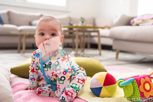 Image of newborn baby boy sitting on colorful blankets