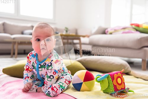 Image of newborn baby boy sitting on colorful blankets