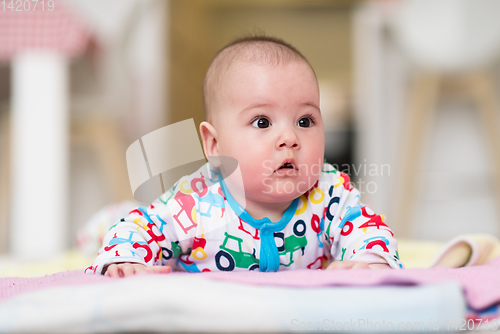 Image of newborn baby boy playing on the floor