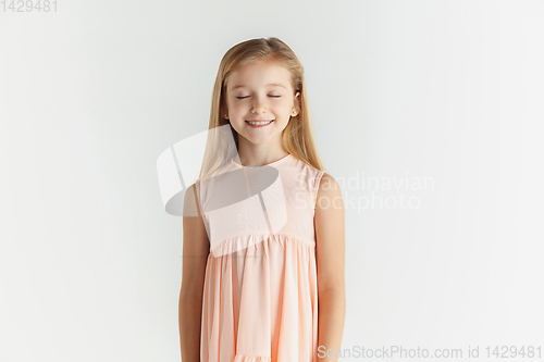 Image of Little smiling girl posing in dress on white studio background