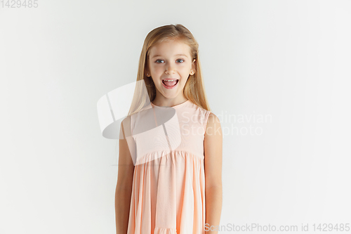 Image of Little smiling girl posing in dress on white studio background