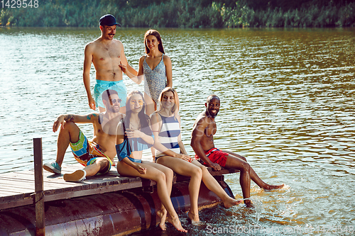 Image of splashing water and laughting on the pier on river