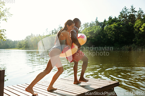 Image of Happy friends having fun, jumping and swimming in river