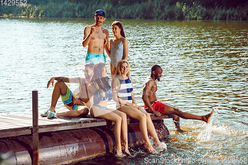 Image of splashing water and laughting on the pier on river