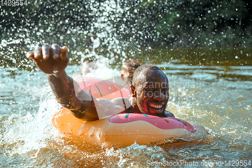 Image of Happy man having fun, laughting and swimming in river