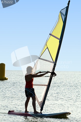 Image of A women on a windsurf on waves