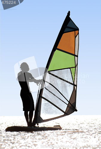 Image of Silhouette of a windsurfer on waves of a bay