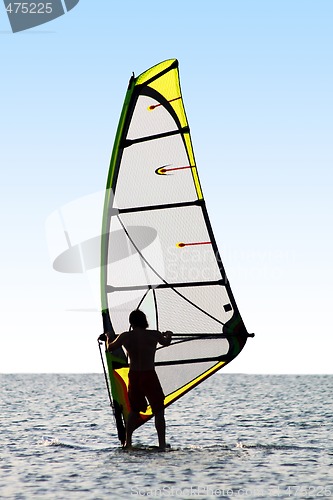 Image of Silhouette of a windsurfer on waves of a sea 