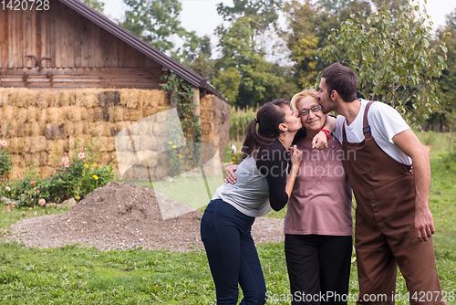 Image of grandmother being kissed by her lovely adult grandchildren