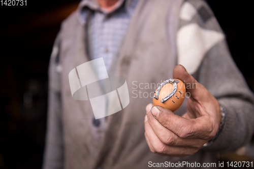 Image of A blacksmith worker showing handmade products ready for sale