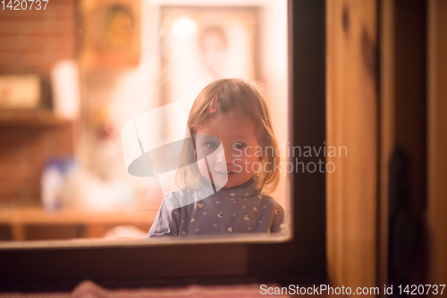 Image of little cute girl playing near the window