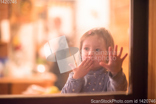 Image of little cute girl playing near the window