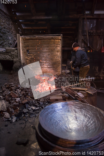 Image of young traditional Blacksmith working with open fire