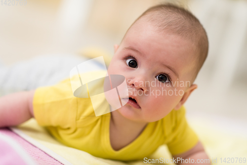 Image of newborn baby boy playing on the floor