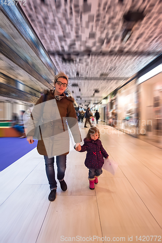 Image of young mother and her little pretty daughter shopping together