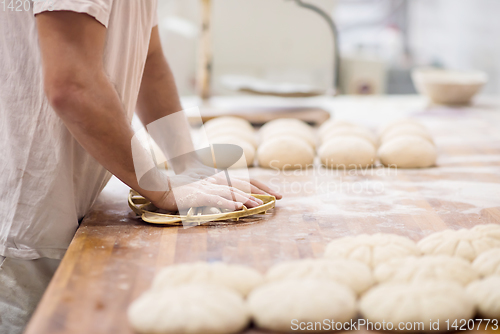 Image of bakery worker preparing the dough