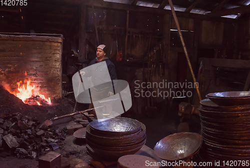 Image of young traditional Blacksmith working with open fire