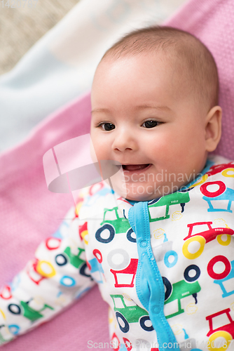 Image of top view of newborn baby boy lying on colorful blankets