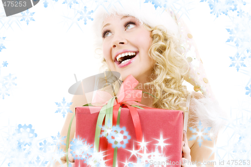Image of cheerful santa helper girl with gift box