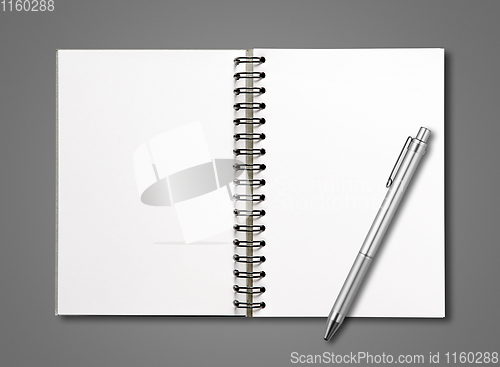 Image of Blank open spiral notebook and pen isolated on dark grey