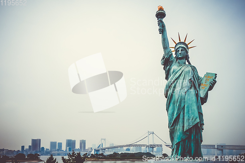 Image of Statue of liberty and tokyo cityscape, Japan