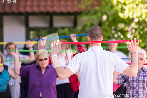 Image of trainer training motivated active healthy senior people