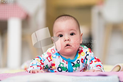 Image of newborn baby boy playing on the floor