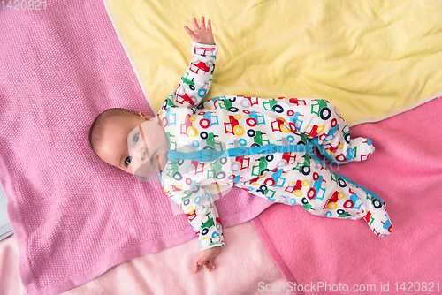 Image of top view of newborn baby boy lying on colorful blankets