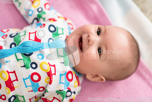 Image of top view of newborn baby boy lying on colorful blankets