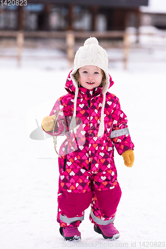 Image of little girl having fun at snowy winter day