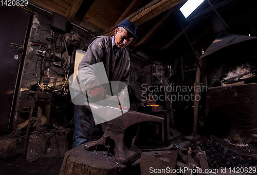 Image of blacksmith manually forging the molten metal