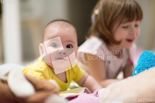 Image of little sister and her baby brother playing at home