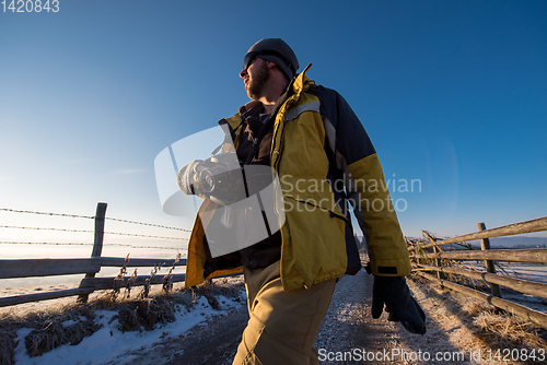 Image of young photographer walking on country road