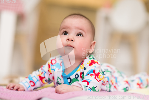 Image of newborn baby boy playing on the floor