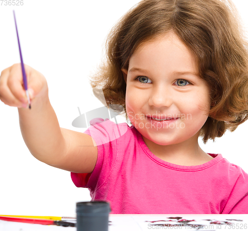 Image of Little girl is painting with gouache