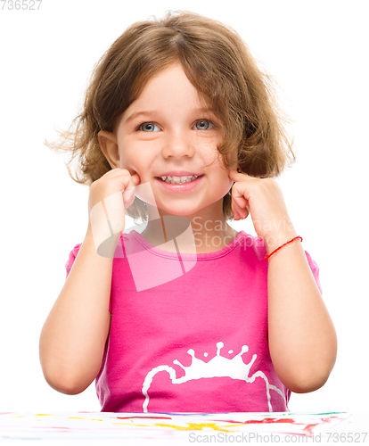 Image of Little girl is painting with gouache